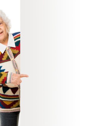 elderly woman alongside of ad board